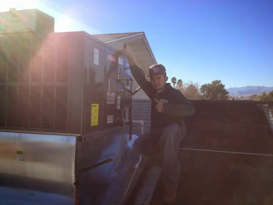 HVAC technician performing Heat Pump Repair on a rooftop unit in Pittsboro