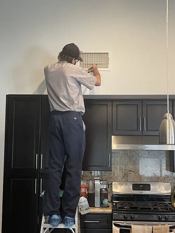 Technician inspecting an air vent during HVAC service in Pittsboro